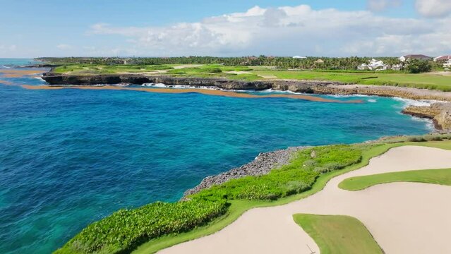 People play golf on Corales Golf Course, Punta Cana Resort in Dominican Republic. Aerial forward ascending