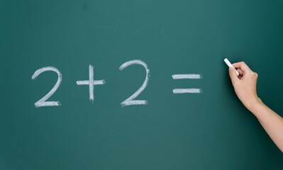 Two add two written on chalkboard
