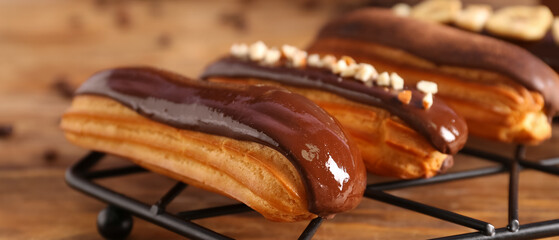 Sweet eclairs on wooden background, closeup