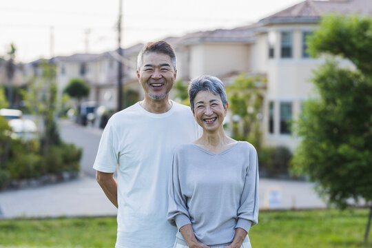 住宅街に立つ日本人シニア夫婦のポートレート