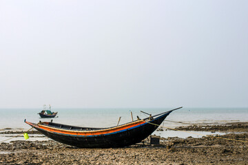 Naklejka na ściany i meble Native wooden fishing boat has been anchored on beach