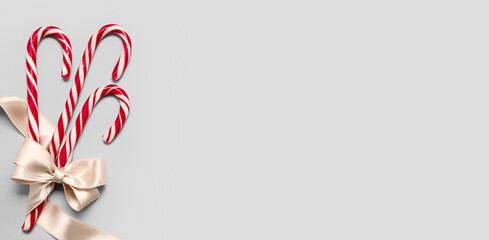 Obraz premium Sweet candy canes on light background with space for text