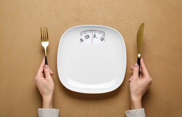 Woman with empty plate and cutlery at table. Diet concept