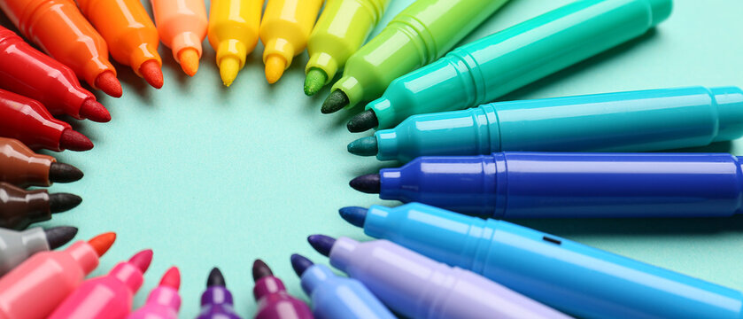 Frame made of markers on blue background, closeup