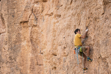 climber climbs the wall. a man is engaged in sport climbing.