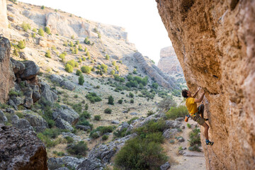 strong man climbs a beautiful rock. the concept of freedom and adventure.