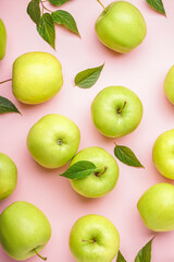 Ripe green apples on pink background