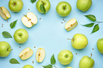 Frame made of whole and cut green apples on color background