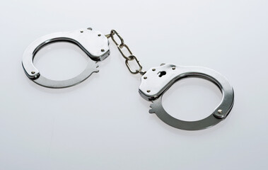 Metal handcuffs against white background