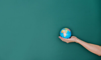 Hand hold a globe in front of blackboard
