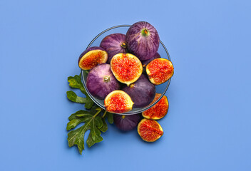 Bowl of fresh ripe figs on color background