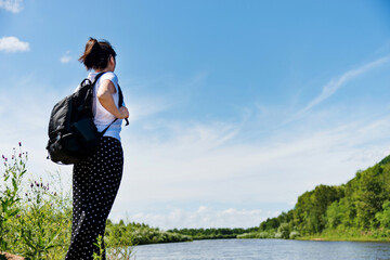 Woman with backpack enjoying lake view