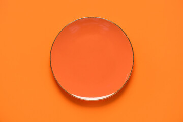 Empty plate on orange background