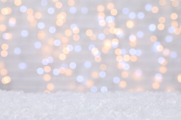 Snow against blurred Christmas lights