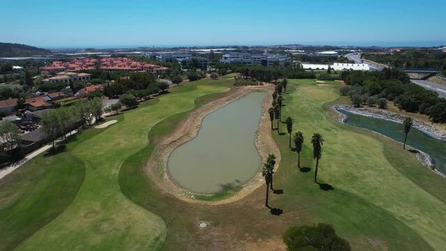 Aerial view around a pool on the Quinta da beloura golf course, in sunny Lisbon, Portugal	- orbit, drone shot