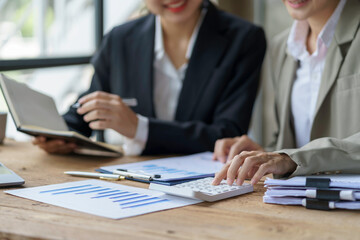 Businesspeople consulting on investment project work and marketing strategy planning and using a calculator and documentation.