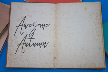 Awesome Autumn word in opened book with vintage, natural patterns old antique paper design.
