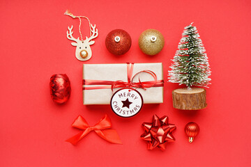 Gift box with Christmas toys and bows on red background