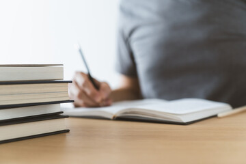 University student studying or learning book, writing or reading textbook at home. Knowledge and skill training online at home. Education and cognition success idea concept
