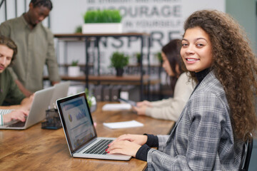 young business woman sitting at a table in a coworking center.