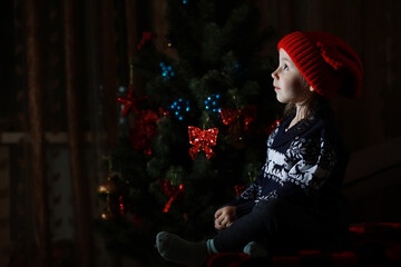 Little girl in red hat waiting for santa