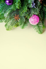 yellow background with fir branches and christmas ball with space for text