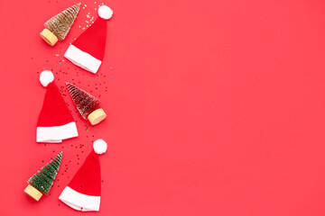 Composition with Santa hats, Christmas decorations and sequins on red background