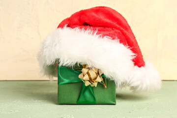 Obraz na płótnie Canvas Christmas gift with Santa hat on table