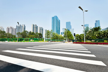 Empty road with zebra crossing and skyscrapers