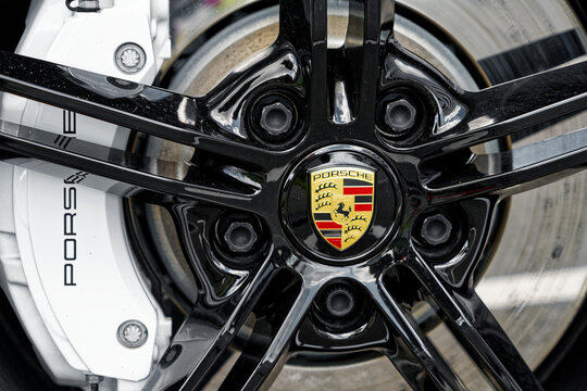 Dortmund, Germany - 08 06 2022 closeup of sports car wheel with black rim and white break pads of Porsche Taycan 4S 