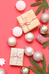 Composition with Christmas gifts, balls and fir branches on red background