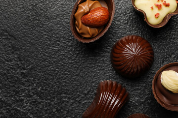 Obraz na płótnie Canvas Different chocolate candies on black background, closeup