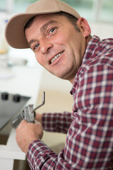 happy repairman working in the kitchen