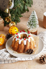 Plate with tasty Christmas cake, tangerines and cones on color background