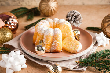 Plate with tasty Christmas cake and decorations on table