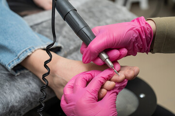 The master makes hardware pedicures to the client. Cuticle treatment. 
