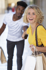 woman pulling his boyfriend to shop more