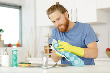 man washing dishes in the sink