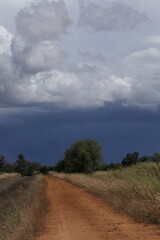 Nimbostratus clouds of an approaching cold front and darkening sky as viewed from a rural country dirt road.