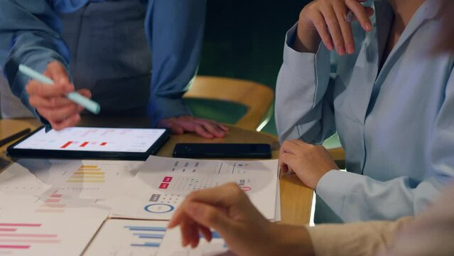 Close-up asia business people meeting plan analysis statistics brainstorm and header of team hold tablet pointing graph chart and employee take note. Finance strategy statistics success concept.