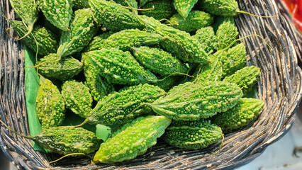 Top View Small Fresh Green Bitter Gourds, Bitter Melon in a basket at farmers markets Organic.