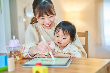 Obraz na płótnie Canvas タブレットPCを使って遊ぶ親子