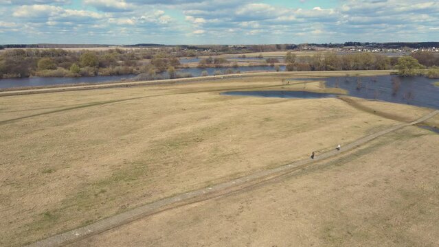 Dangerous river flood, spring flood and flooded fields, aerial view. Snow is melting, high water levels, flooded banks, fields, trees. Warm sunny day, soft light. UHD 4K.