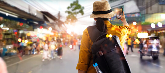 Female tourist traveling backpacker and take a photo in jatujak, chatuchak outdoor market in...