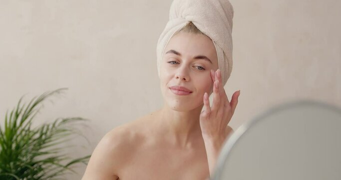 Woman dropping serum on face. European girl applying serum collagen moisturizer