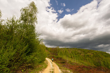 Beautiful country road in spring in remote rural area in Eastern Europe and storm April sky