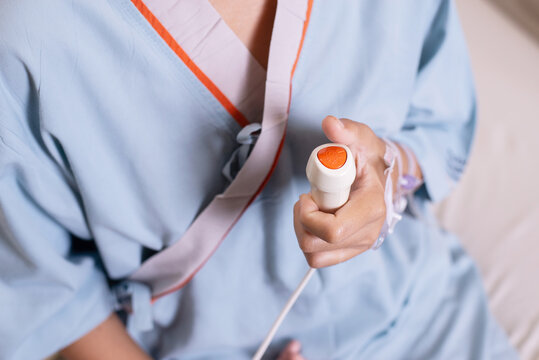 Patient hands using nurse call button for emergency bell in hospital