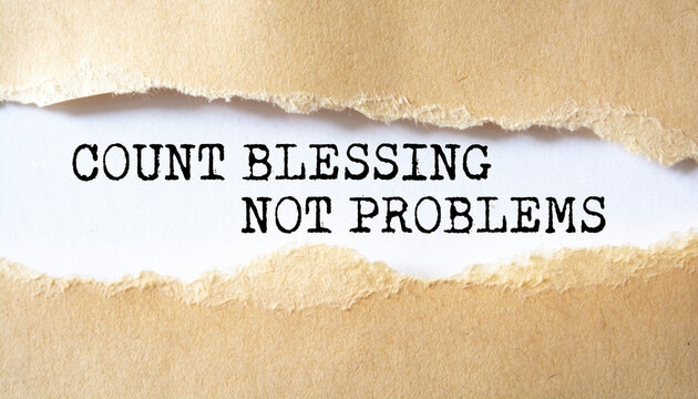 Count Blessing Not Problems word written under torn paper.