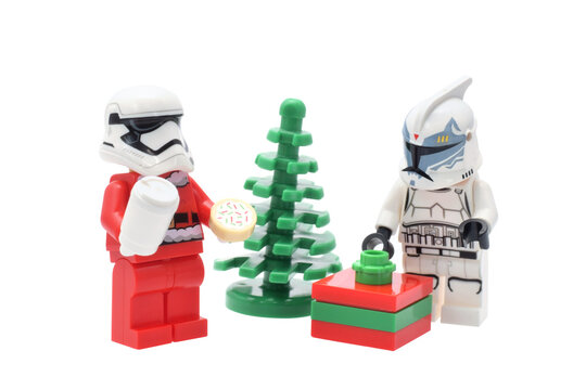 Lego minifigure of warrior Star Wars in Santa Claus costume with milk and cookie on white. Editorial illustrative image of popular plastic toy constructor.