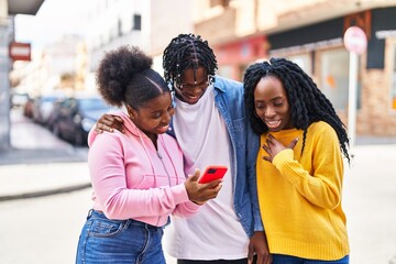African american friends standing together using smartphone at street